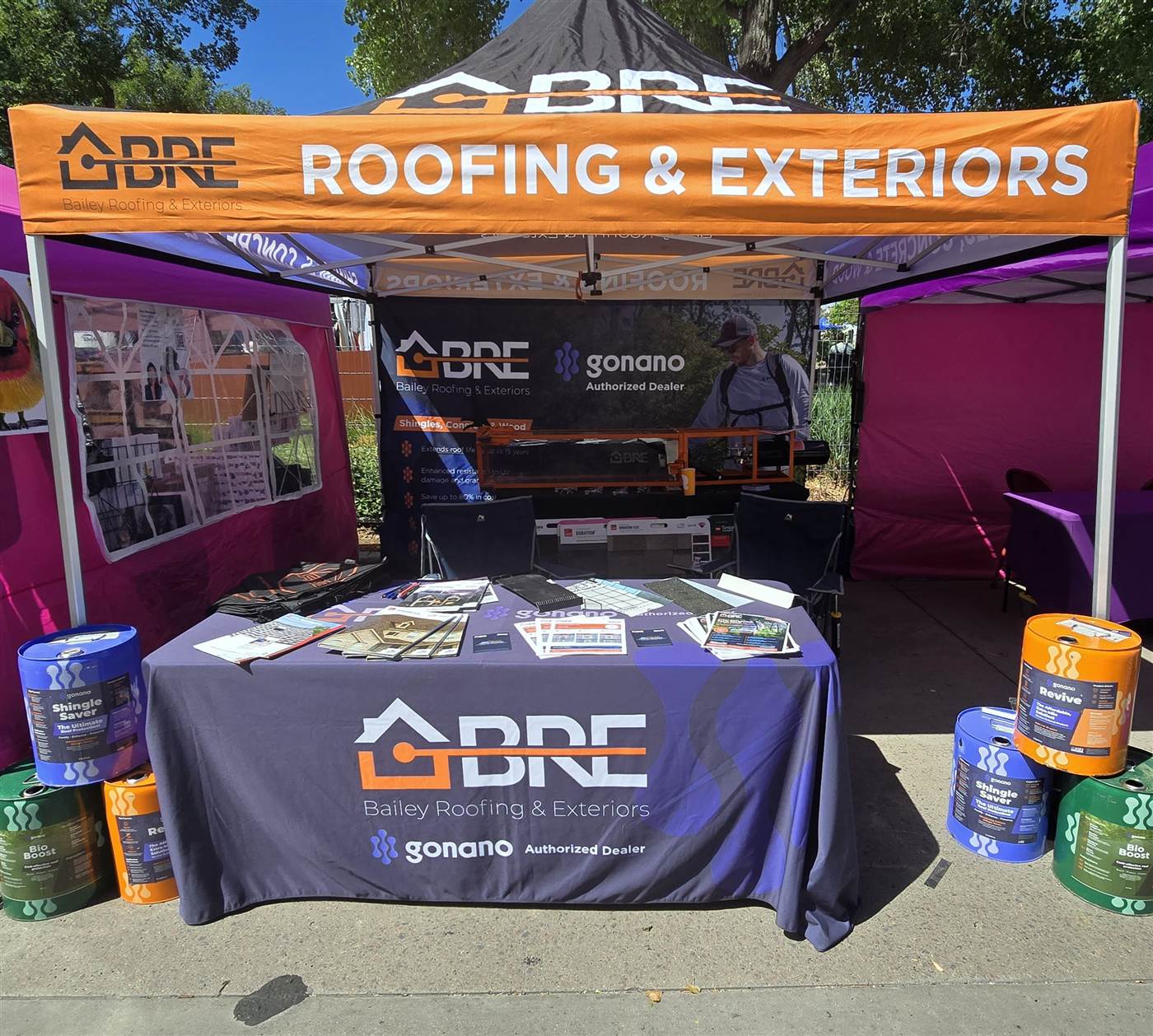 Bailey Roofing booth table at Parker Days with shingle samples, brochures, and the GoNano giveaway, June 2026