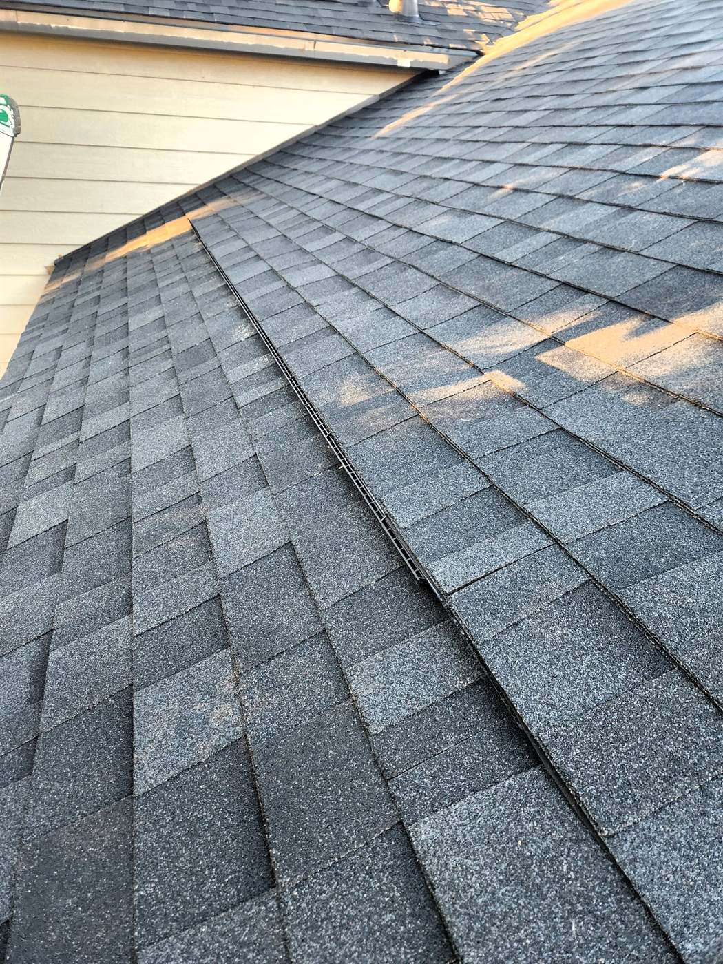 Finished rooftop intake vent blended into new Owens Corning shingles on a Bailey Roofing replacement, September 2024