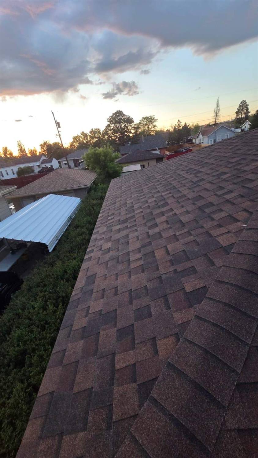 New brown architectural shingle roof installed by Bailey Roofing at golden hour on East 22nd Street in Cheyenne, Wyoming, June 2026