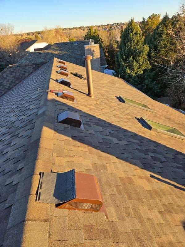 Finished Bailey Roofing reroof at golden hour with new skylights, vents, and chimney flashing complete, East Powers Drive, Piney Creek, Centennial, March 2024